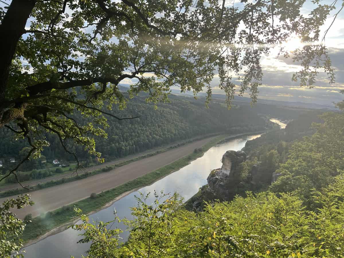 תצפית פנורמית מרהיבה על נהר אלבה (Elbe River) הזורם דרך עמק פתלתל בתוך הפארק הלאומי שווייצריה הסקסונית (Saxon Switzerland National Park) במדינת סקסוניה