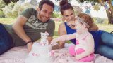 תינוקת בת שנה עם ההורים ועוגת יום הולדת בצילומי גיל שנה בטבע מסדרת הצילומים של אנדה יואל